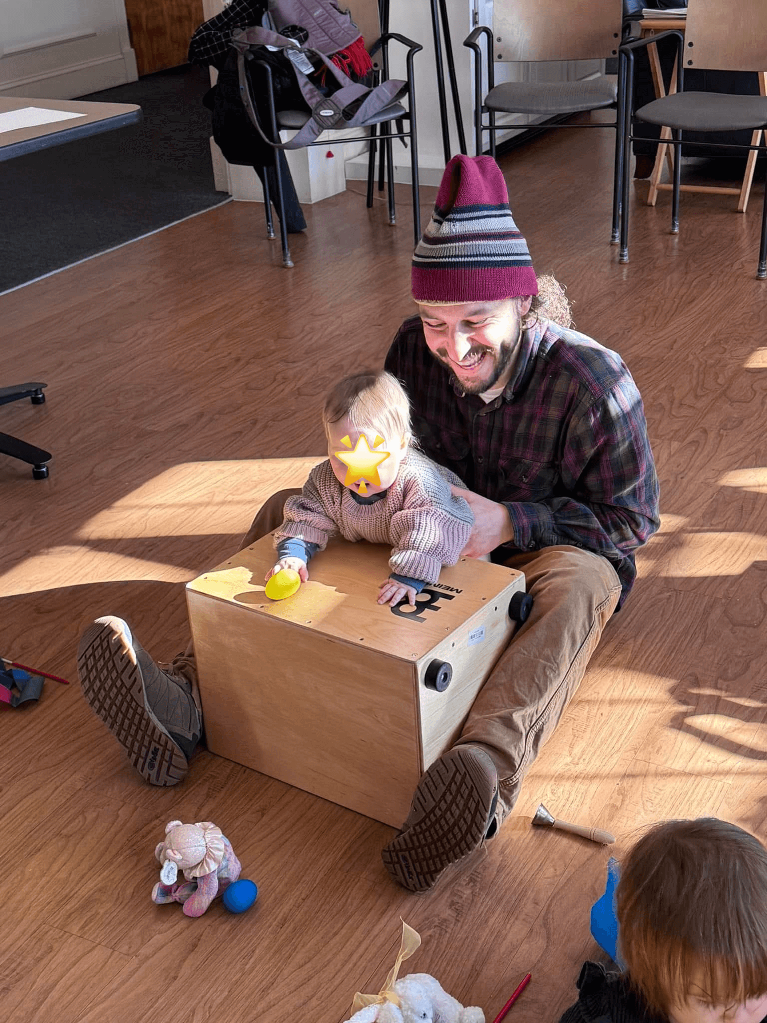 Child joyfully playing the cajon with his dad